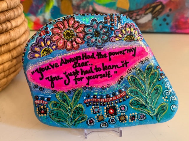 Decorative, hand painted stone from Santorini, with floral patterns and motivational quote on a stand